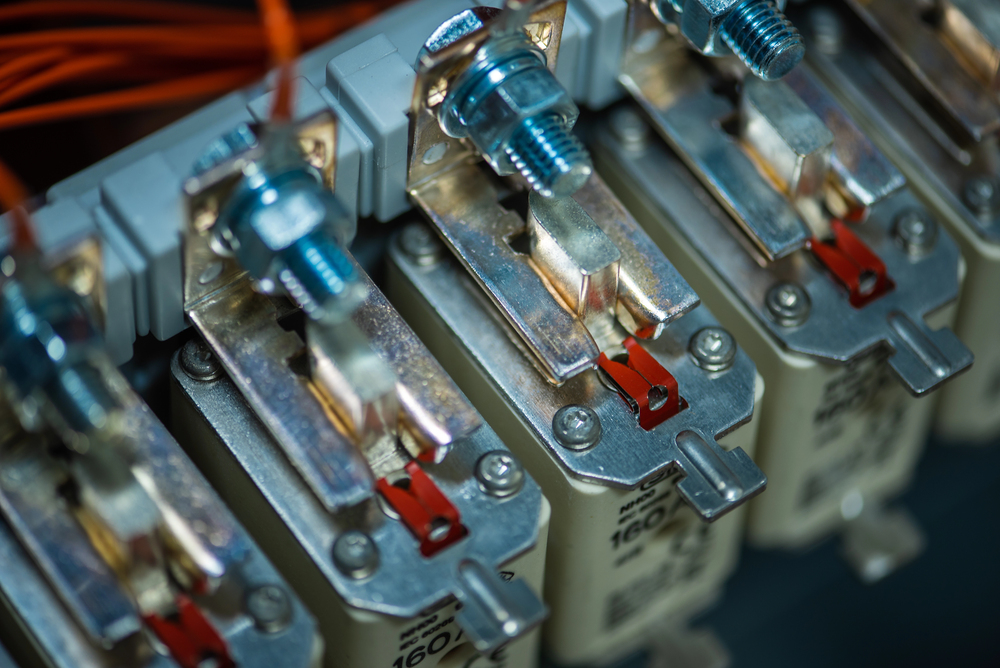 Close-up view of several electrical fuses mounted in a row, with visible screws and orange wires attached at the top—ideal for appliance wiring and dedicated circuit installation.